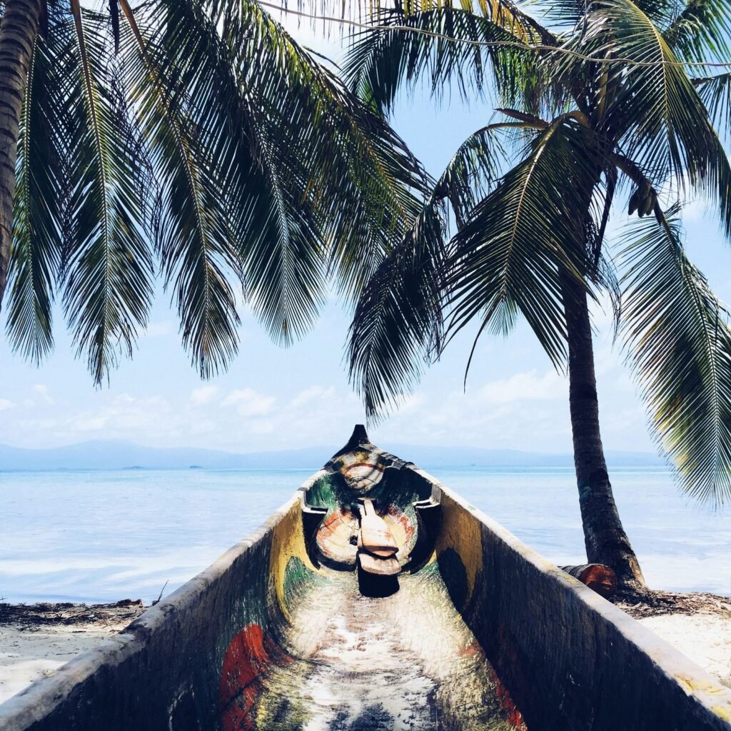 Traditional wooden canoe (ulu) resting at the water's edge in Kuna Yala, Panama
