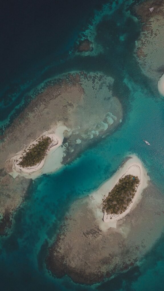 Aerial view of small palm-covered islands surrounded by coral reef in Guna Yala, Panama